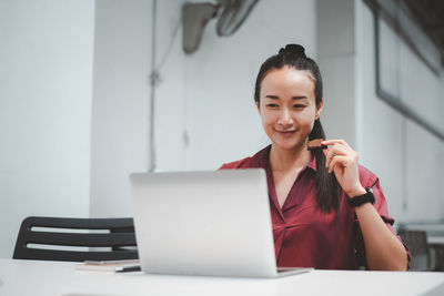 Portrait of smiling young woman using smart phone