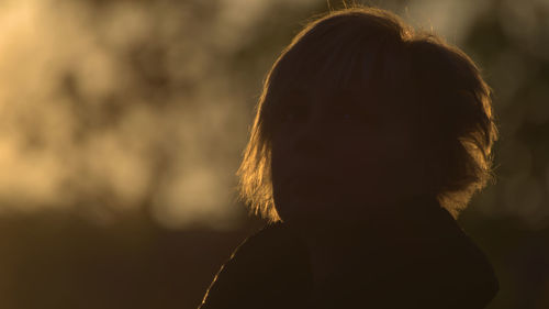 Close-up portrait of young woman looking away outdoors