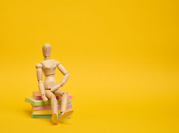 Close-up of figurine against yellow background