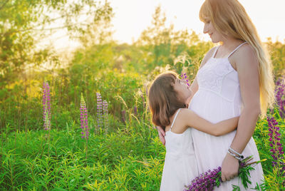 Cute girl embracing pregnant mother