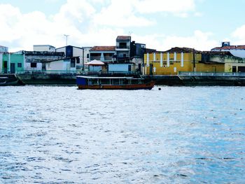 Houses by sea against sky