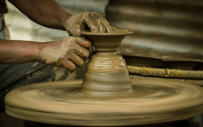 Cropped image of man making pot in workshop