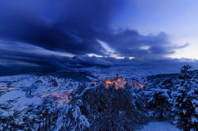 Scenic view of snowcapped mountains against sky at sunset