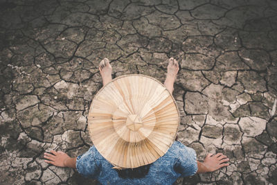 High angle view of girl sitting on drought field