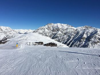 Scenic view of snowcapped mountains against clear blue sky