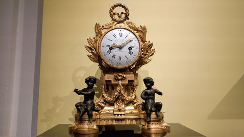 Close-up of clock against wall at home