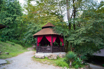 Red house amidst trees in forest