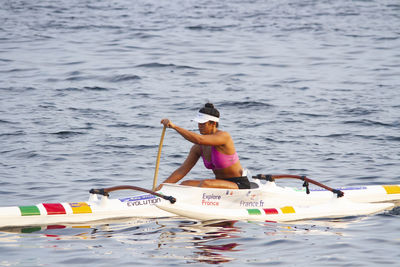 Rear view of woman sitting in sea