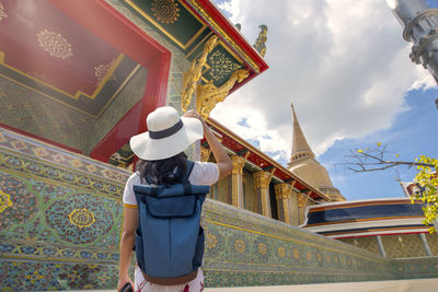 Young women travel to thailand to see the beauty of temples and art in thailand.