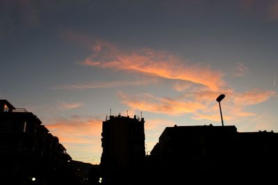 Low angle view of silhouette buildings against sky