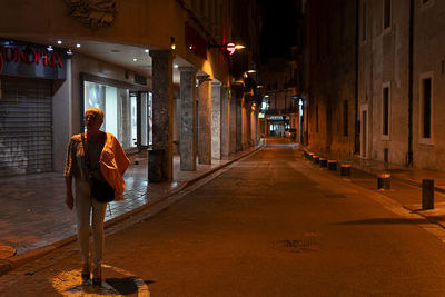 Rear view of woman standing in illuminated building at night