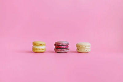 The view from the top. purple background with space for your text and three colored macaroons.