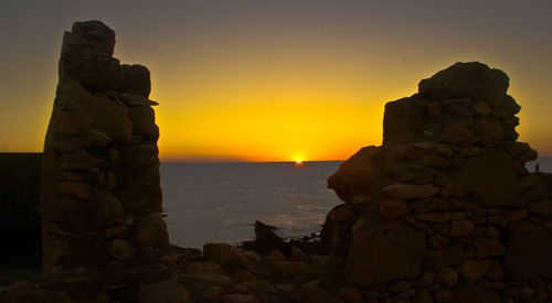 Silhouette of rock formations at seaside