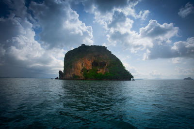 Rock formation in sea against sky