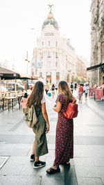 Women standing on walkway in city