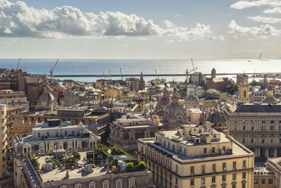 High angle view of townscape by sea against sky