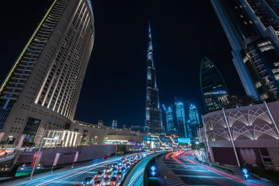 High angle view of light trails on road against buildings