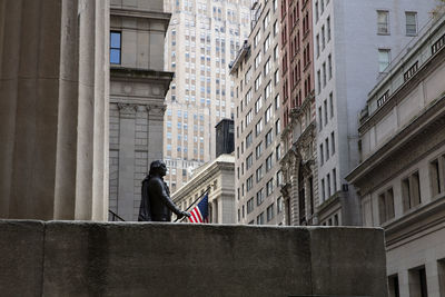 Rear view of man standing against buildings in city