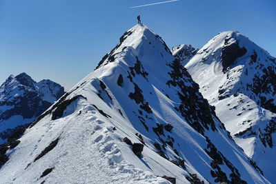 Figure on top of a pointy snowy mountain