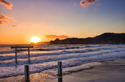 Scenic view of beach against sky during sunset