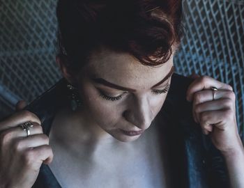 Close-up of young woman adjusting collar