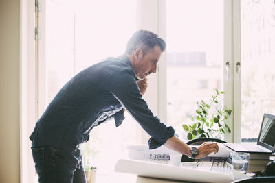 Profile of man on the phone in office at home