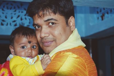 Close-up of man carrying baby