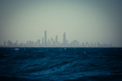 View of calm sea with cityscape in background