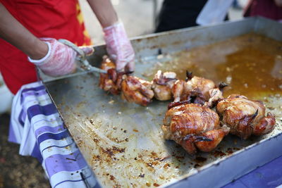 Close-up of man working on barbecue grill