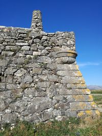 Built structure on field against blue sky