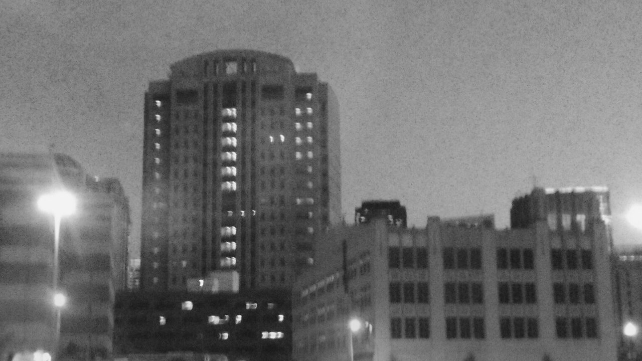 LOW ANGLE VIEW OF ILLUMINATED CITYSCAPE AGAINST SKY