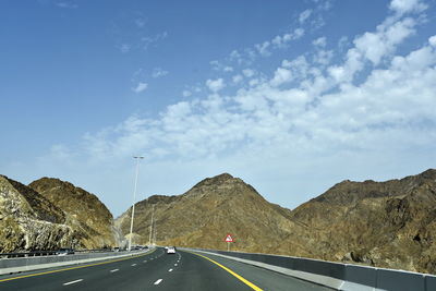 Country road against sky