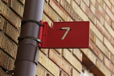 The seven digit with white text on red background as signboard mounted on a lamppost