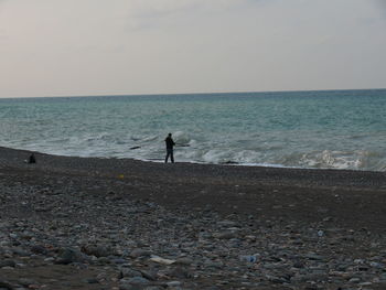 Man standing on beach against clear sky