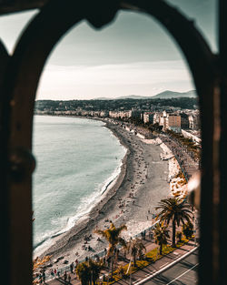 High angle view of city by sea against sky