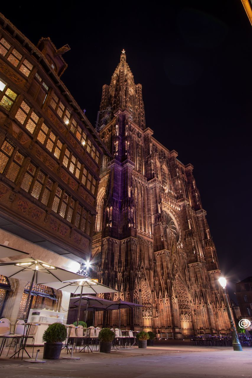 LOW ANGLE VIEW OF ILLUMINATED BUILDING AT NIGHT