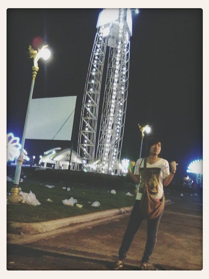 transfer print, night, leisure activity, arts culture and entertainment, lifestyles, men, illuminated, auto post production filter, full length, motion, architecture, built structure, city, rear view, standing, amusement park, building exterior, casual clothing