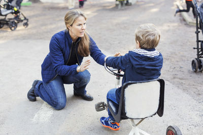 Angry teacher shouting at boy on tricycle