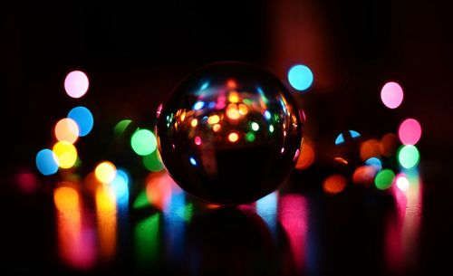 Close-up of christmas decoration against illuminated colorful lights