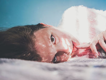 Portrait of woman lying on bed