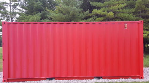 Red metal structure against trees