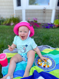 Portrait of cute girl sitting in pink hat