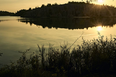 Scenic view of lake against sky at sunset