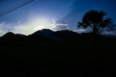Scenic view of silhouette field against sky at sunset