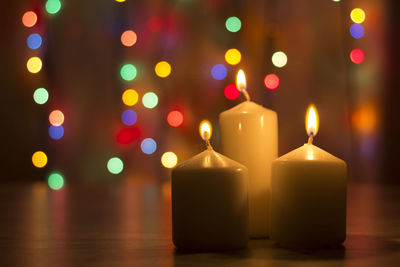 Close-up of illuminated candles on table
