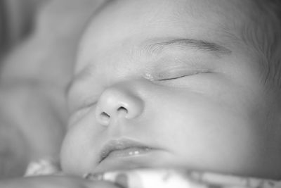 Close-up of baby sleeping on bed