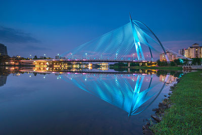 Illuminated bridge over river at night