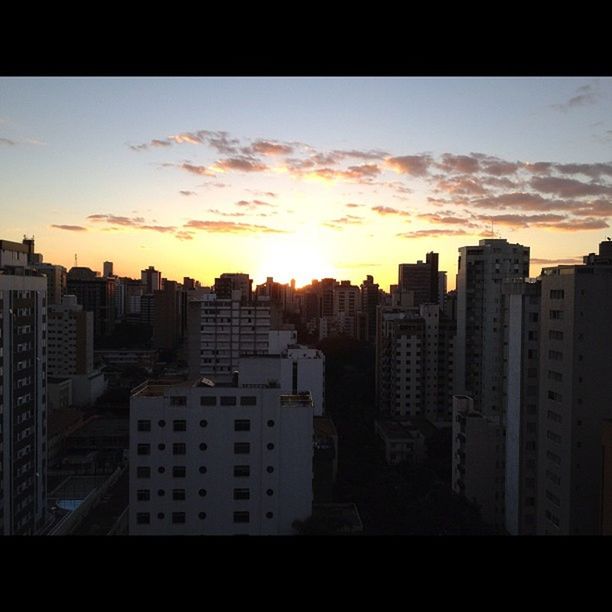 building exterior, sunset, architecture, city, built structure, sky, cityscape, silhouette, cloud - sky, skyscraper, residential building, orange color, residential structure, city life, building, sun, sunlight, residential district, cloud, office building