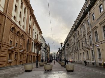 People walking on street amidst buildings in city