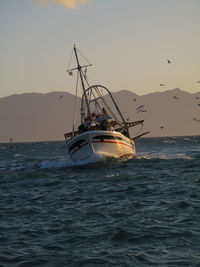 Sailboat on sea against sky during sunset